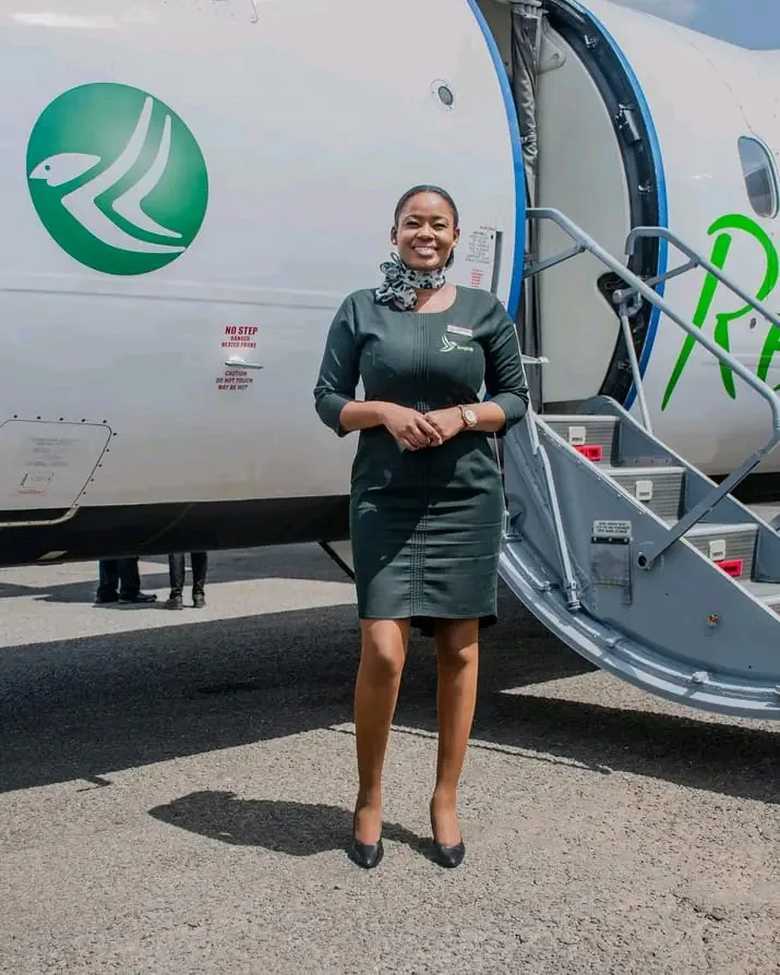 Renegade Air crew member beside the airline’s green bird emblem on the aircraft fuselage